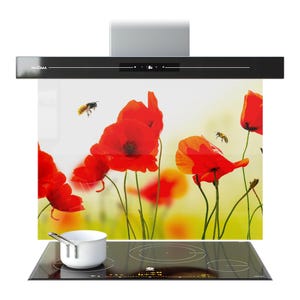 Peut inclure: Hotte de cuisine noire avec un panneau de verre représentant un champ de coquelicots. La hotte est au-dessus d'une table de cuisson à induction noire avec une casserole blanche. Deux abeilles volent près des coquelicots.