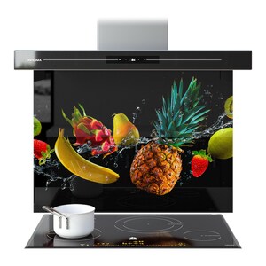Puede incluir: Campana extractora negra con un panel de vidrio con un diseño vibrante de salpicaduras de frutas. La imagen incluye una piña, plátano, fresa y otras frutas. Una olla blanca se encuentra en la encimera negra.