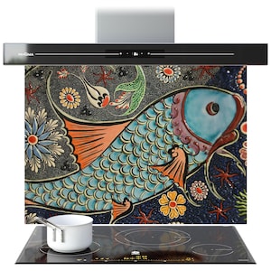 Può includere: Cappa da cucina nera con il marchio "PRISMA". Sotto, un paraschizzi decorativo con un colorato motivo a pesce. Una pentola bianca è su un piano cottura a induzione nero. Il design del pesce comprende elementi blu, arancioni e floreali.
