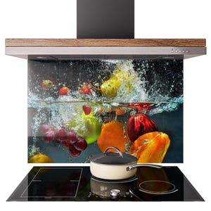 Può includere: Una cappa da cucina con un paraschizzi in vetro con un vivace design a spruzzi di frutta. L'immagine include un piano cottura nero con una pentola color crema e un manico in acciaio inossidabile.
