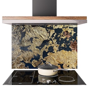 May include: A modern kitchen range hood with a wooden trim and a black chimney. The backsplash features a gold leaf design against a dark blue background. A cream-colored pot with a silver handle sits on a black stovetop.