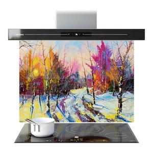 Op de afbeelding: Zwarte afzuigkap met een kleurrijk winterlandschapsschilderij. Het schilderij toont een besneeuwd pad door een bos met levendige tinten geel, roze en blauw. Een witte pot staat op een zwarte inductiekookplaat.