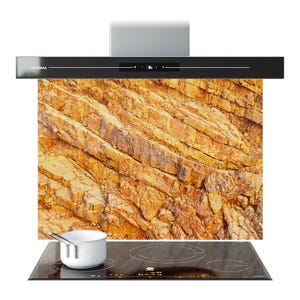 May include: A contemporary black cooker hood with a digital display above a glass panel with a rock formation design. Below, a black induction hob with a white saucepan.