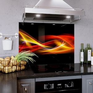 May include: A black kitchen backsplash with a vibrant abstract design in shades of red, orange, and yellow. The artwork features flowing, dynamic lines against a dark background. The backsplash is installed above a black stovetop.