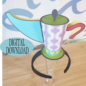 May include: A purple and green teapot-shaped hat with a blue and yellow spout, attached to a black headband. The hat has a white lace pattern and yellow hearts.