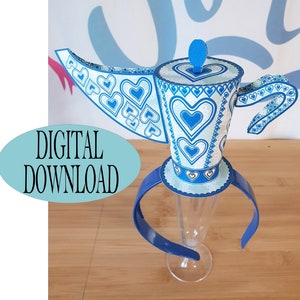 May include: A blue and white teapot-shaped headband with a heart pattern. The headband is made of paper and is designed to be worn as a costume accessory. The headband is on a clear plastic stand.