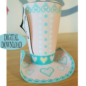 May include: A printable template for a pink and teal paper hat shaped like a top hat. The hat has a white heart pattern and teal polka dots. The hat is labeled "Digital Download".