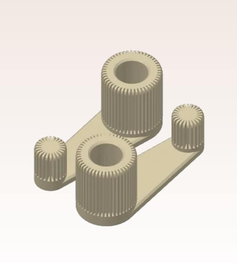 May include: Two beige mechanical components with cylindrical bodies and ridged surfaces. Each component has a central hole. The components are connected by flat, rectangular arms. One smaller cylindrical component is also present.