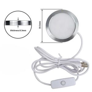 May include: A round, silver LED light with a white center, measuring 59.5mm in diameter and 8.3mm thick. It has a white USB cable with an on/off switch. The light is designed for various applications.
