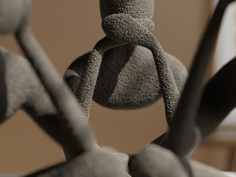 K&ouml;nnte beinhalten: Nahaufnahme einer strukturierten, grauen Skulptur mit einer abgerundeten zentralen Form und gebogenen, armartigen Ausl&auml;ufern. Die Skulptur hat eine raue, k&ouml;rnige Oberfl&auml;che und einen verschwommenen, neutralen Hintergrund.