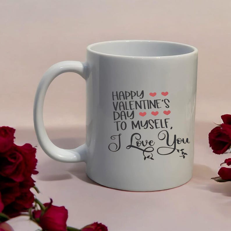 May include: White ceramic mug with a curved handle. The mug features the text "HAPPY VALENTINE'S DAY TO MYSELF, I Love You" in black script with red heart accents. The mug is set against a light pink background.
