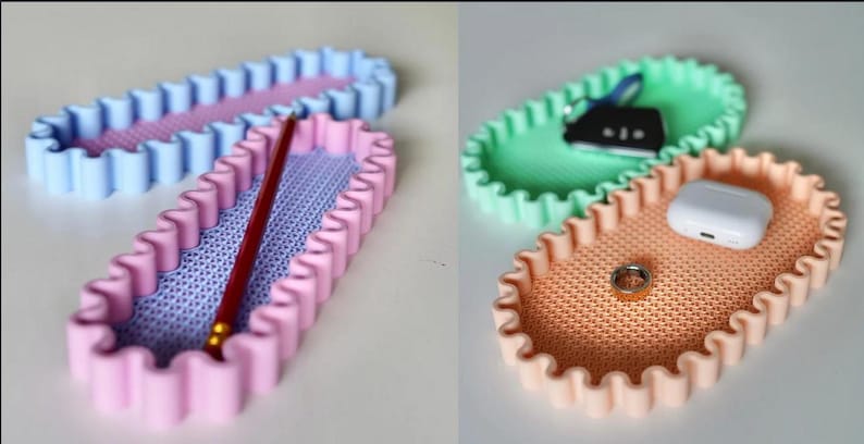 May include: Oval-shaped trays in pastel colors. One pink tray holds a red pencil. Another tray is light blue. A third tray is peach-colored, holding a ring and a white case. A green tray holds keys.