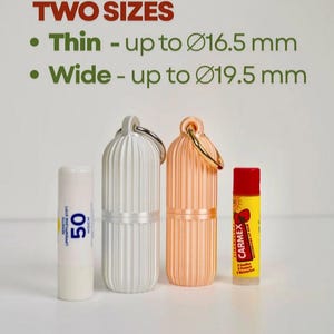 May include: Two cylindrical ribbed cases with metal rings, one white and one peach, displayed next to two lip balm sticks. Text reads: TWO SIZES, Thin - up to 16.5 mm, Wide - up to 19.5 mm. The cases are designed to hold items of these specific diameters.