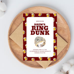 May include: An invitation with the text "DREW'S RING DUNK" on a red background with beer mugs. The invitation includes the date, time, and location. The invitation is on a wooden plate with a brown envelope.