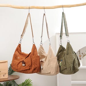 Puede incluir: Una taza de cerámica blanca con un asa negra y el texto "But First, Coffee" en negrita negra. La taza se encuentra sobre un fondo borroso, sugiriendo un ambiente acogedor.