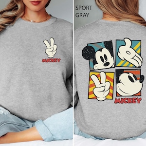 This vintage-style Mickey Hand sweatshirt features the classic gloved hand design on a cozy fleece-lined pullover. Ideal for Disney World and Disneyland trips, it brings nostalgic charm to any outfit. Soft, warm, and perfect for park days, chilly evenings, or themed group photos. A timeless gift for Disney lovers and Mickey fans.