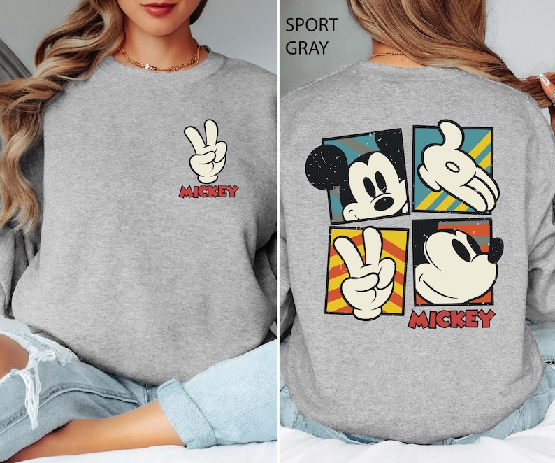 This vintage-style Mickey Hand sweatshirt features the classic gloved hand design on a cozy fleece-lined pullover. Ideal for Disney World and Disneyland trips, it brings nostalgic charm to any outfit. Soft, warm, and perfect for park days, chilly evenings, or themed group photos. A timeless gift for Disney lovers and Mickey fans.