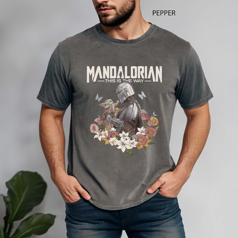 This vintage floral Mandalorian shirt features a soft, boho-style design of Mando with "This Is The Way" text on Comfort Colors® fabric. Perfect for Star Wars fans, Disney park trips, or May the 4th outfits. A unique and stylish fan gift for any galaxy traveler.