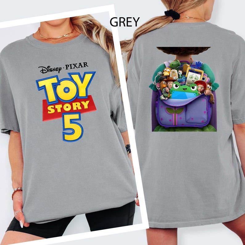 K&ouml;nnte beinhalten: Ein graues T-Shirt mit dem Disney Pixar Toy Story 5 Logo auf der Vorderseite in Blau, Gelb und Rot. Die R&uuml;ckseite des Shirts zeigt eine Grafik eines lila Rucksacks, der mit verschiedenen animierten Spielzeugfiguren gef&uuml;llt ist, darunter eine gr&uuml;ne.