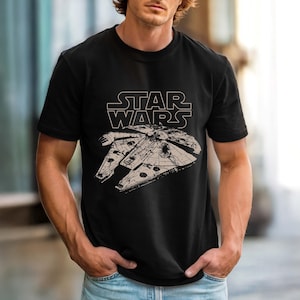 Peut inclure: T-shirt noir avec un dessin blanc du Faucon Millenium et le logo Star Wars. Le motif est centré sur le devant. Le t-shirt a des manches courtes et un col rond.
