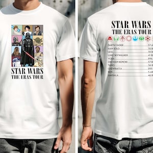 May include: White t-shirt featuring a pop art style graphic of Star Wars characters, including Darth Vader and Yoda. The text "STAR WARS THE ERAS TOUR" is printed below the graphic. The back of the shirt lists characters and their eras.