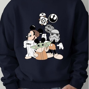 Star Wars Minnie Baby Yoda sweatshirt featuring Baby Yoda, Minnie Mouse, and Darth Vader. Cozy crewneck perfect for Disneyland family trips and Star Wars fans in 2025. Soft, warm pullover with galaxy-themed design combining Disney magic and Star Wars adventure.