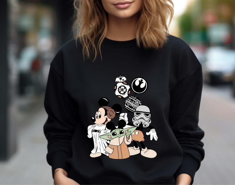 Puede incluir: Sudadera negra con un dise&ntilde;o de Mickey Mouse como la Princesa Leia, Baby Yoda, un Stormtrooper e iconos de Star Wars. El dise&ntilde;o incluye a BB-8 y el s&iacute;mbolo de la Alianza Rebelde. Cuello redondo.