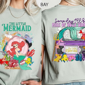 This vintage-style Little Mermaid tee features two-sided artwork of Princess Ariel, printed on soft Comfort Colors fabric. Perfect for Disney girls’ trips, Magic Kingdom park days, or fans of nostalgic princess fashion. With dreamy pastels and a retro vibe, it's ideal for Disneyland adventures.