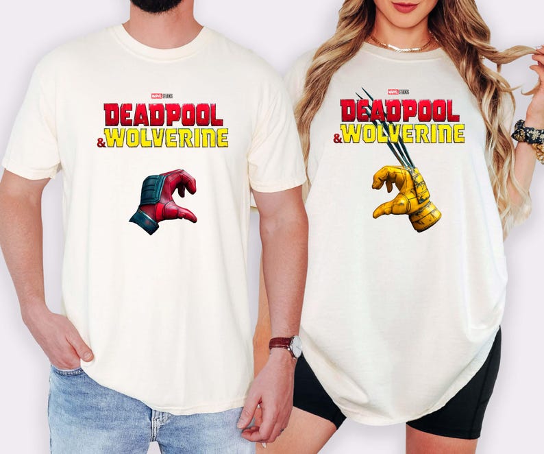 Puede incluir: Camisetas color crema con el texto "DEADPOOL & WOLVERINE" en rojo y amarillo. Una camiseta muestra una mano roja y azul, la otra una mano amarilla con garras. Son prendas informales.