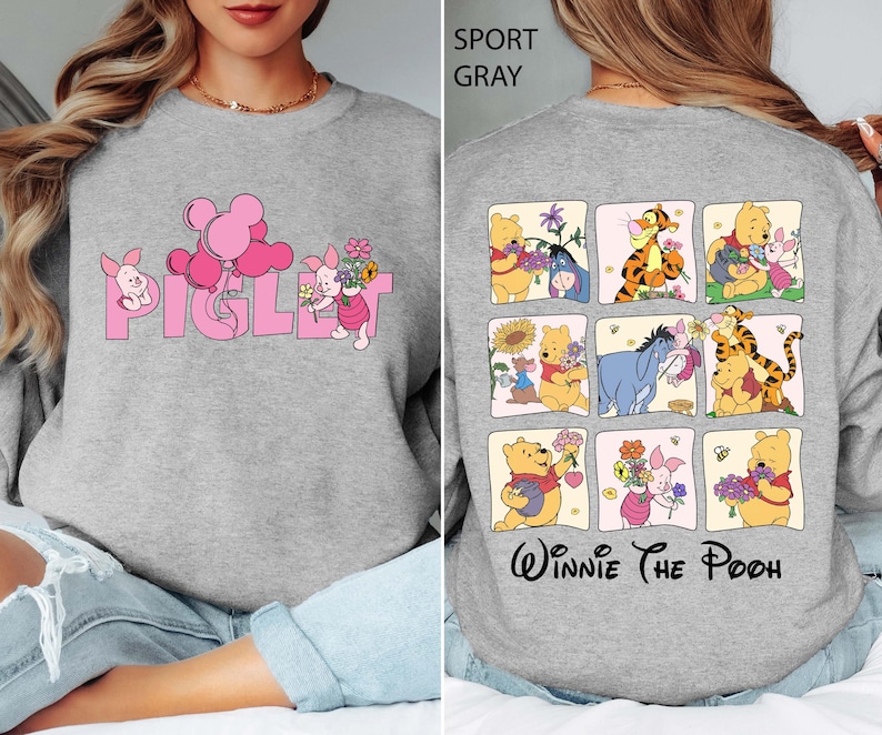 May include: Sport grey sweatshirt with the word "Piglet" in pink, a cartoon pig, and balloons. The back displays a grid of Winnie the Pooh characters, including Pooh, Tigger, and Eeyore, with the words "Winnie The Pooh" underneath.