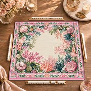 Könnte beinhalten: Eine quadratische Mahjong-Matte mit einer detaillierten Korallenriff-Illustration, die rosa und grüne Algen, verschiedene Muscheln und Seesterne zeigt. Der Rand ist mit einem wiederkehrenden Muschelmuster verziert.