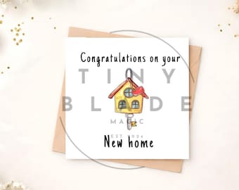 Può includere: Biglietto di auguri quadrato con la scritta "Congratulations on your New home" e un'illustrazione di chiave di casa. La chiave ha un ciondolo a forma di casa con un cuore rosso. Il biglietto è su una busta marrone.