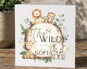 Può includere: Un biglietto di auguri bianco con un'illustrazione ad acquerello di un leone, una tigre, una giraffa e un elefante. La carta presenta il testo "Two Wild Magic" e il nome "Sofia". Il design include una fetta di legno e fogliame verde.