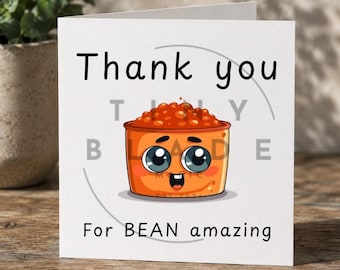 Può includere: Un biglietto di auguri bianco con le parole "Thank you" in nero. Sotto c'è un'immagine a cartoni animati di una ciotola di fagioli con occhi e bocca. Il testo "For BEAN amazing" è sotto l'immagine.