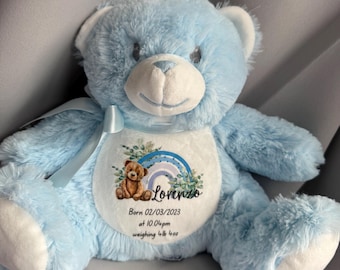Può includere: Un orsacchiotto di peluche azzurro con la pancia bianca. L'orso ha un nastro blu legato al collo. La pancia dell'orso presenta un arcobaleno, un'illustrazione di orsacchiotto e il nome "Lorenzo" con i dettagli della nascita: Nato il 02/03/2023 alle 22:04, peso 1,93 kg.