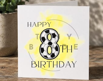 Può includere: Biglietto di auguri bianco con la scritta "HAPPY 8TH BIRTHDAY". Il numero 8 è disegnato come un pallone da calcio. Un lavaggio ad acquerello giallo e un cerchio grigio accentuano il design. Il biglietto è su una superficie di legno.