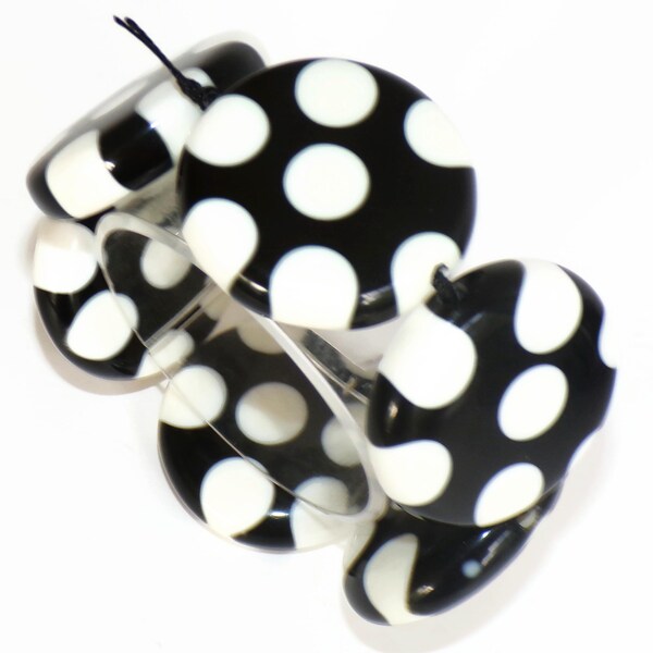 Pulsera elástica Sobral Dots NF con lunares blancos sobre cuentas negro azabache, hecha a mano por artistas