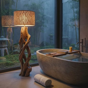 May include: A floor lamp with a natural, twisted driftwood base and a cylindrical lampshade featuring a repeating leaf cutout pattern. The lamp emits a warm glow, standing beside a stone bathtub with a wooden tray and a rolled white towel.