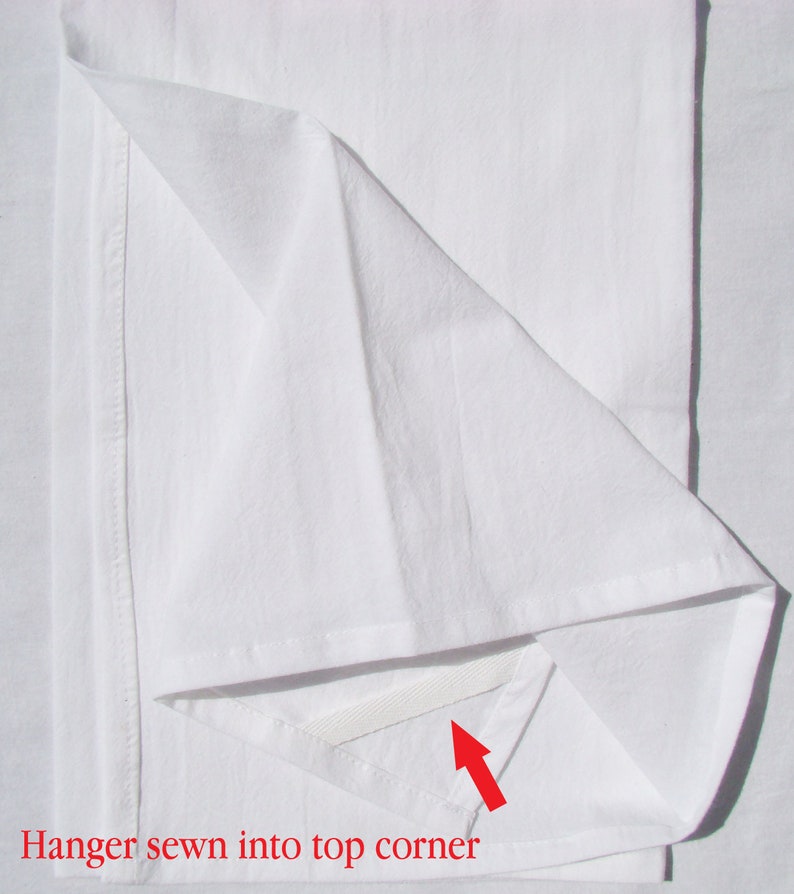 May include: A white fabric sheet with a white hanger loop sewn into the top corner. The loop is visible through a small opening in the fabric.