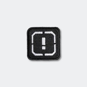 May include: Black square patch with a white exclamation point inside a white outlined square. The patch has a white stitched border and is set against a white background.
