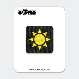 Puede incluir: Un parche cuadrado bordado en negro que presenta un icono de sol amarillo brillante con ocho rayos puntiagudos. El parche se muestra sobre una tarjeta blanca con el texto TONZ en la parte superior y la URL WWW.TOONZPOP.COM en la parte inferior.