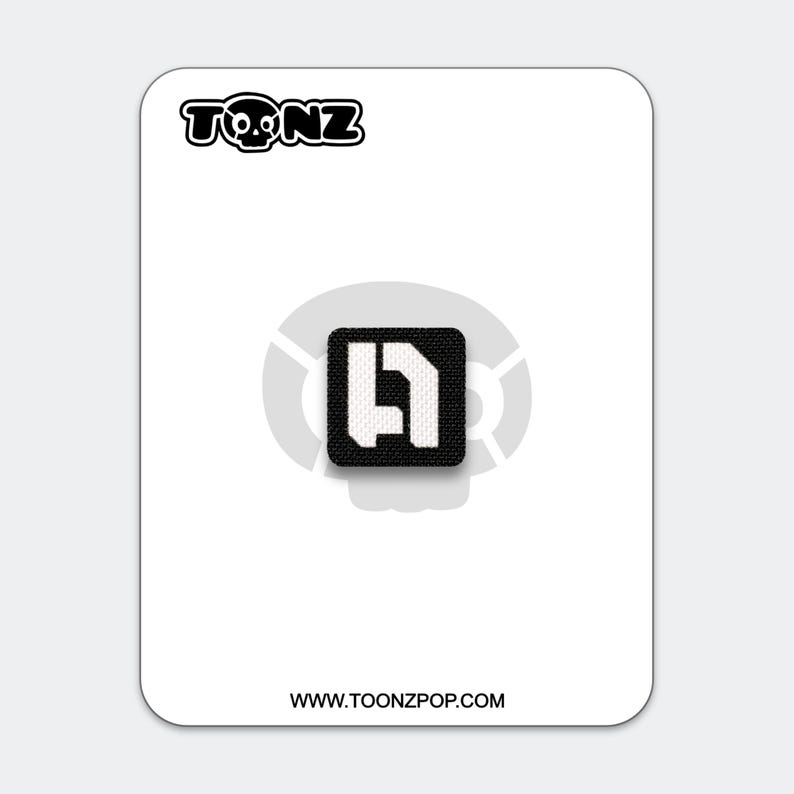 May include: A black and white patch with the text "TOONZ" above a square logo. The logo is a black square with a white abstract design. The website address "WWW.TOONZPOP.COM" is printed at the bottom.