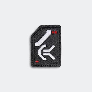 May include: Black patch with a white and red graphic design. The patch has a rectangular shape with rounded corners and a black border. The graphic includes a stylized arrow and two red dots.
