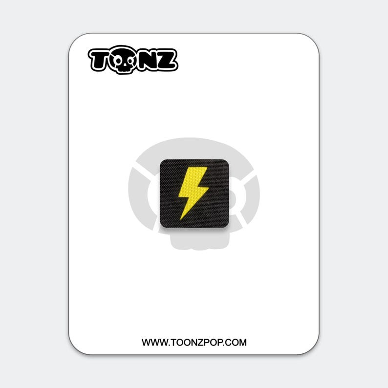 May include: A square black patch featuring a yellow lightning bolt icon, centered on a white backing card. The card displays the text TONZ at the top and WWW.TOONZPOP.COM at the bottom, with a faint gray skull graphic behind the patch.