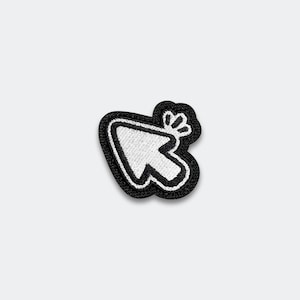 May include: A black and white embroidered patch in the shape of a computer mouse cursor arrow. The design features a white arrow outline with a solid white center, surrounded by a thick black border and a small white click icon at the top right.