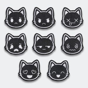May include: A collection of seven black cat face patches with various embroidered expressions. Each patch features a white outline and detailed facial features, including sad, angry, and loving expressions. The patches are designed for fabric application.