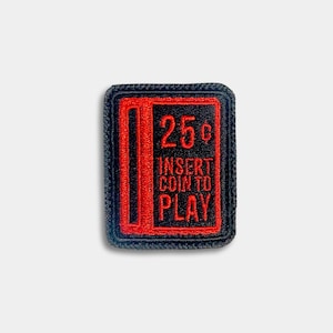 May include: A rectangular patch with a black border and a black center. The center features a red design of a vintage arcade game coin slot with the text "25¢ INSERT COIN TO PLAY" in red.