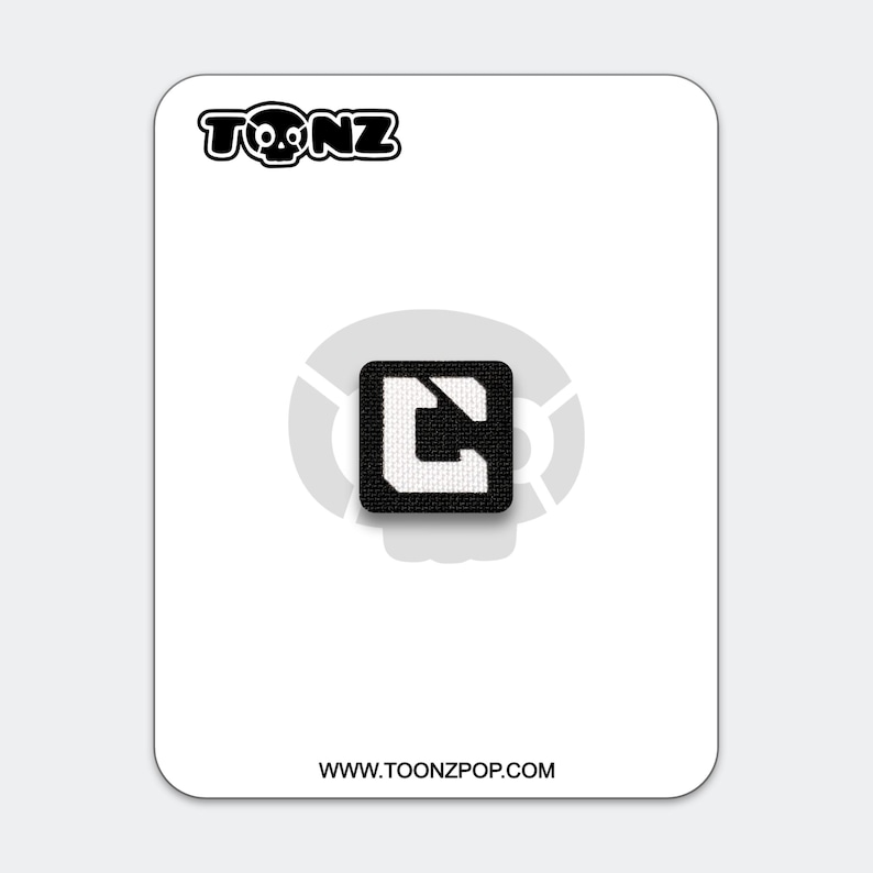 May include: A black and white patch featuring the TOONZ logo and a square design with a white "C" shape. The patch is on a white card with the website address www.toonzpop.com.