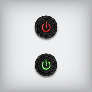May include: Two black, circular patches with embroidered power symbols. The top patch has a red power symbol, while the bottom patch features a green power symbol. The patches are set against a light gray background.