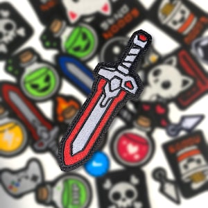 May include: Embroidered patch featuring a stylized sword with a red and white blade and a black handle. The patch is surrounded by other embroidered patches with various designs, including potions, skulls, and video game controllers.